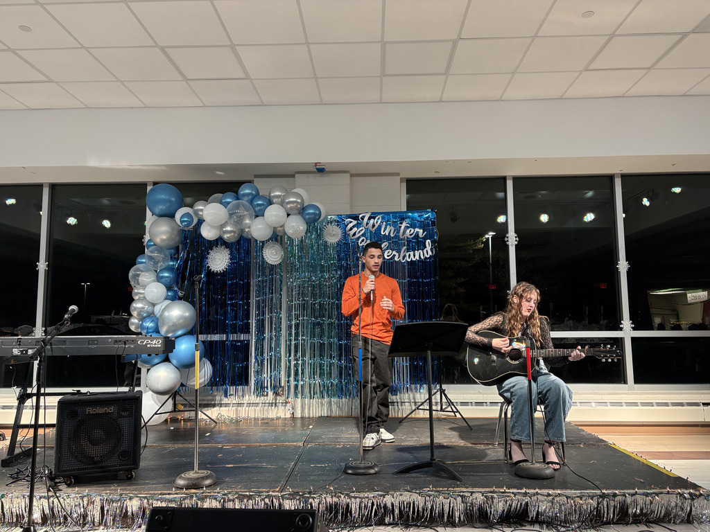 ASHS students playing guitar and singing during a duet at Open Mic Night