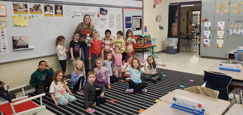 First grade students smiling with Roz the Robot
