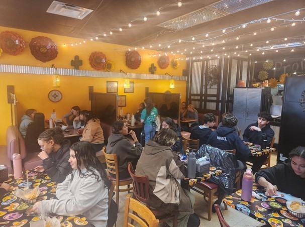 Students sitting at tables enjoying an authentic Mexican meal