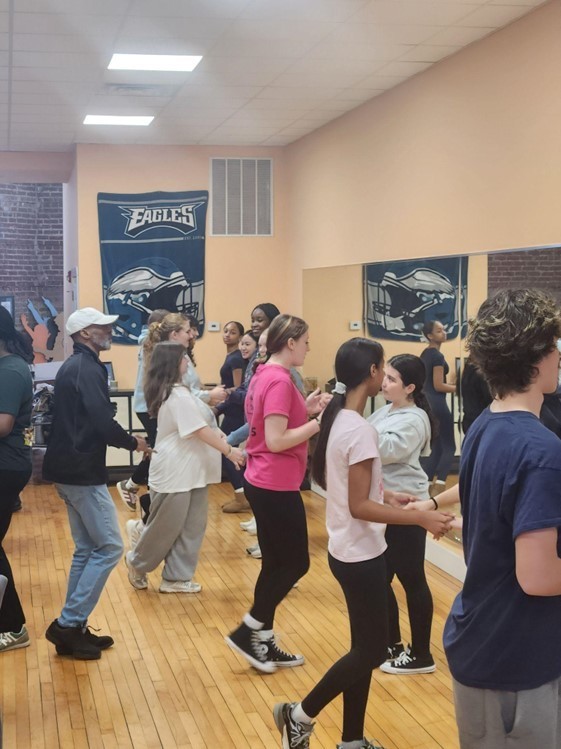 Students learn latin dancing from an instructor in Flaco's Dance Factory