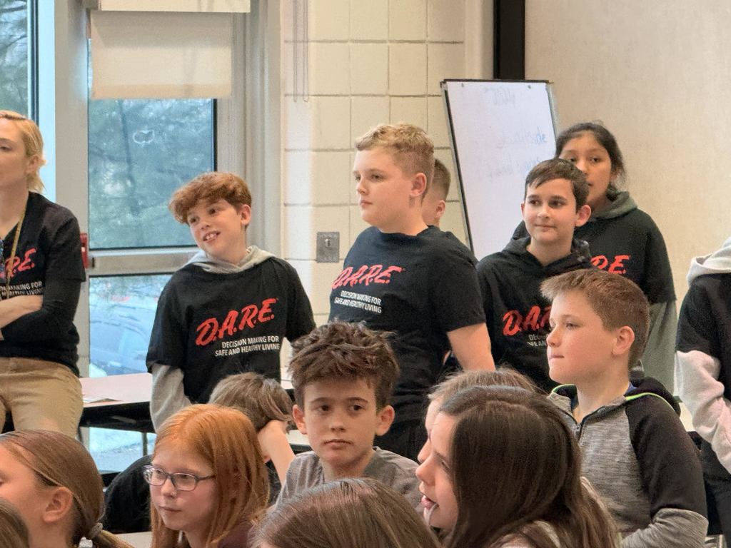 grade 5 students listening while sitting