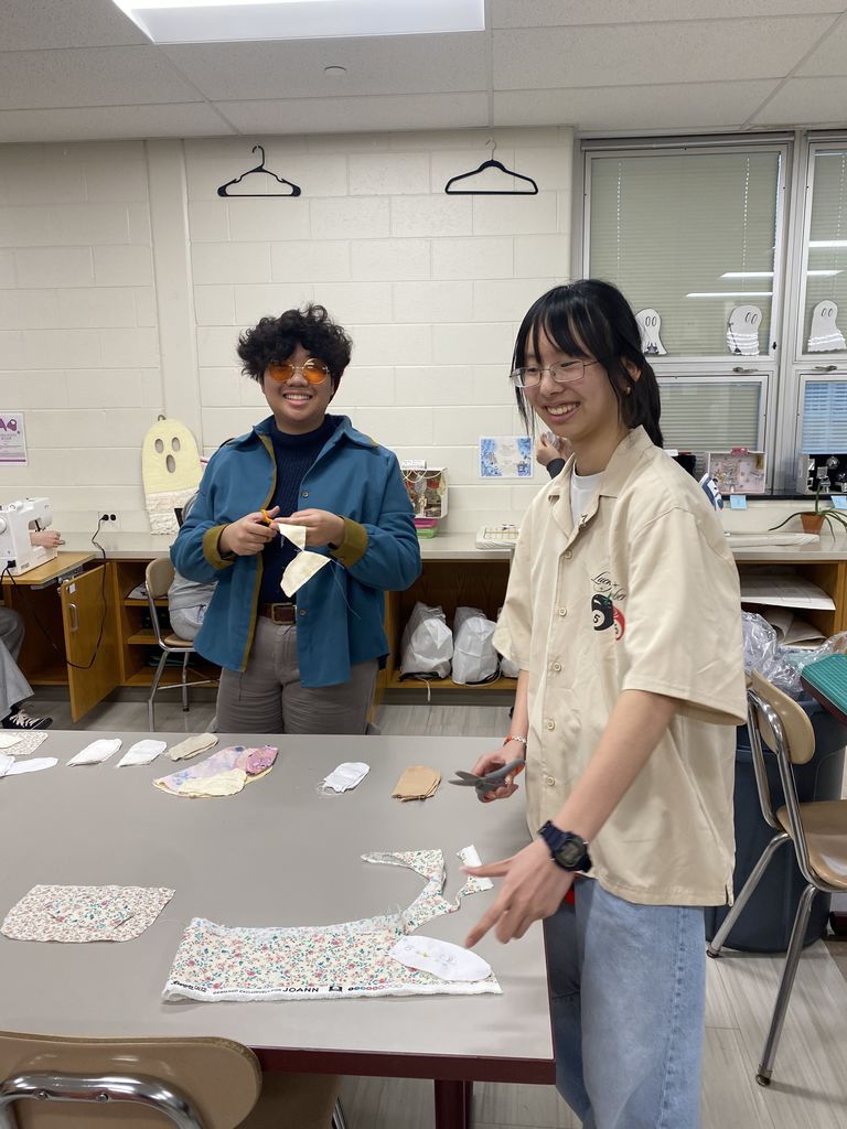 two people cutting cloth