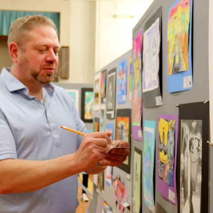 Dr. Fecher admires student's artwork on display