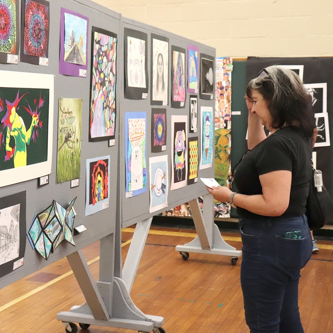 Dr. Mowry admires the student artwork on display