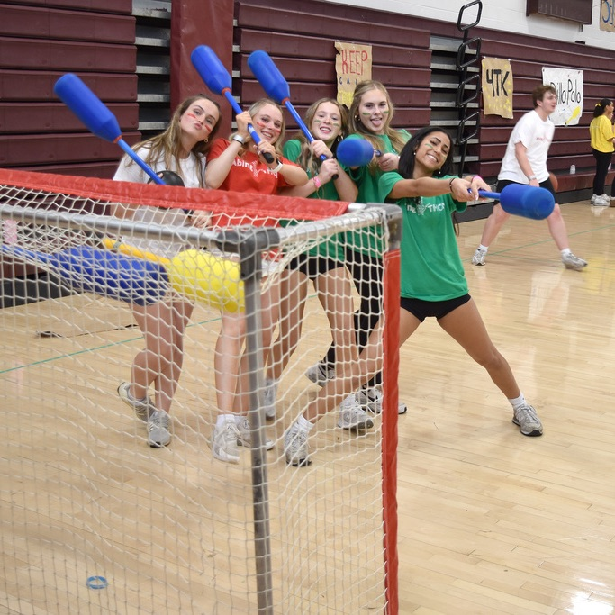 5 students from assorted teams pose with sports gear at AbingTHON