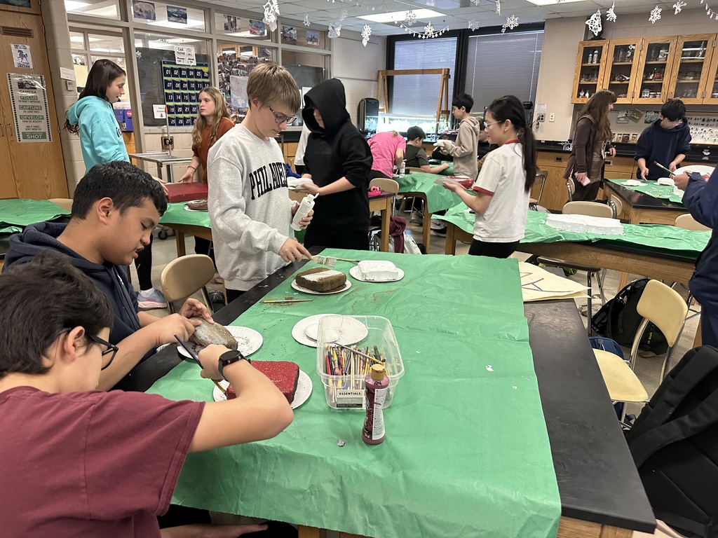 Image of students in the Going Green Club finished giving the school spirit rock garden its spring refresh.