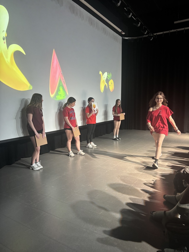students doing a game presentation with signs 