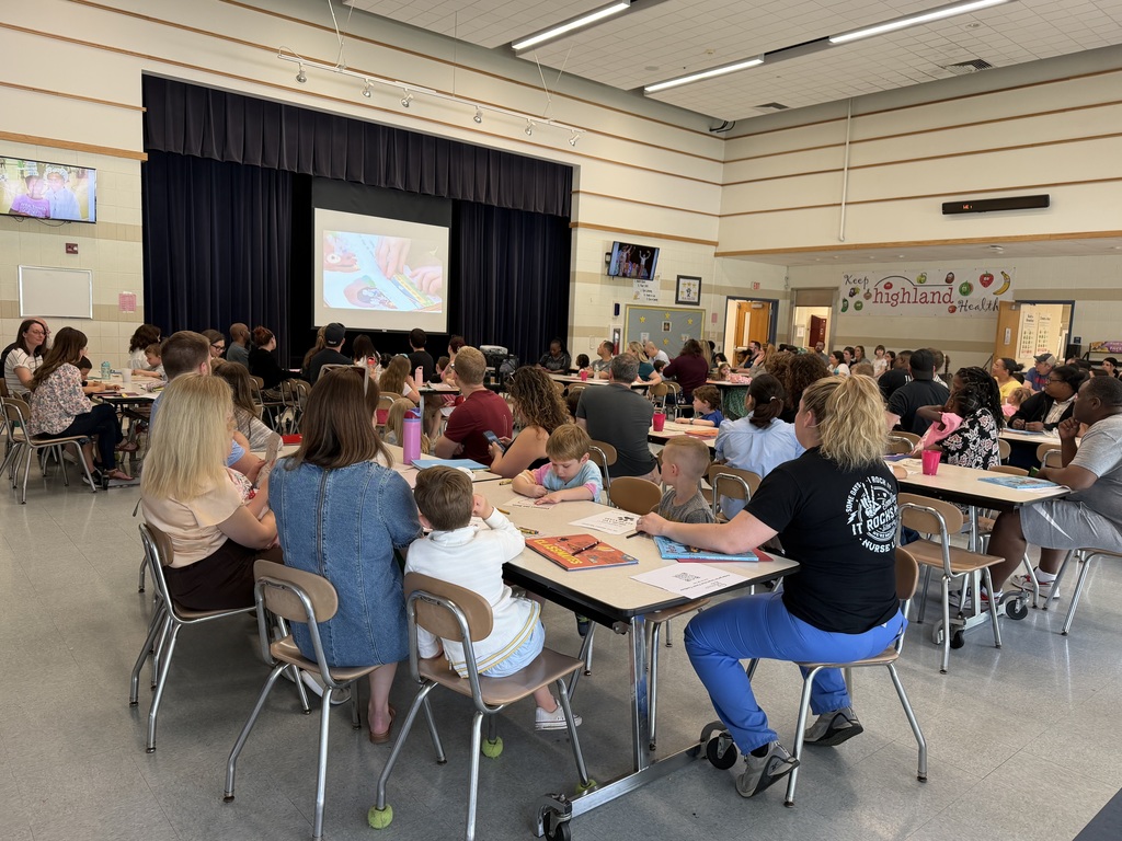 Parents and children at kindergarten orientation in the cafeteria. 