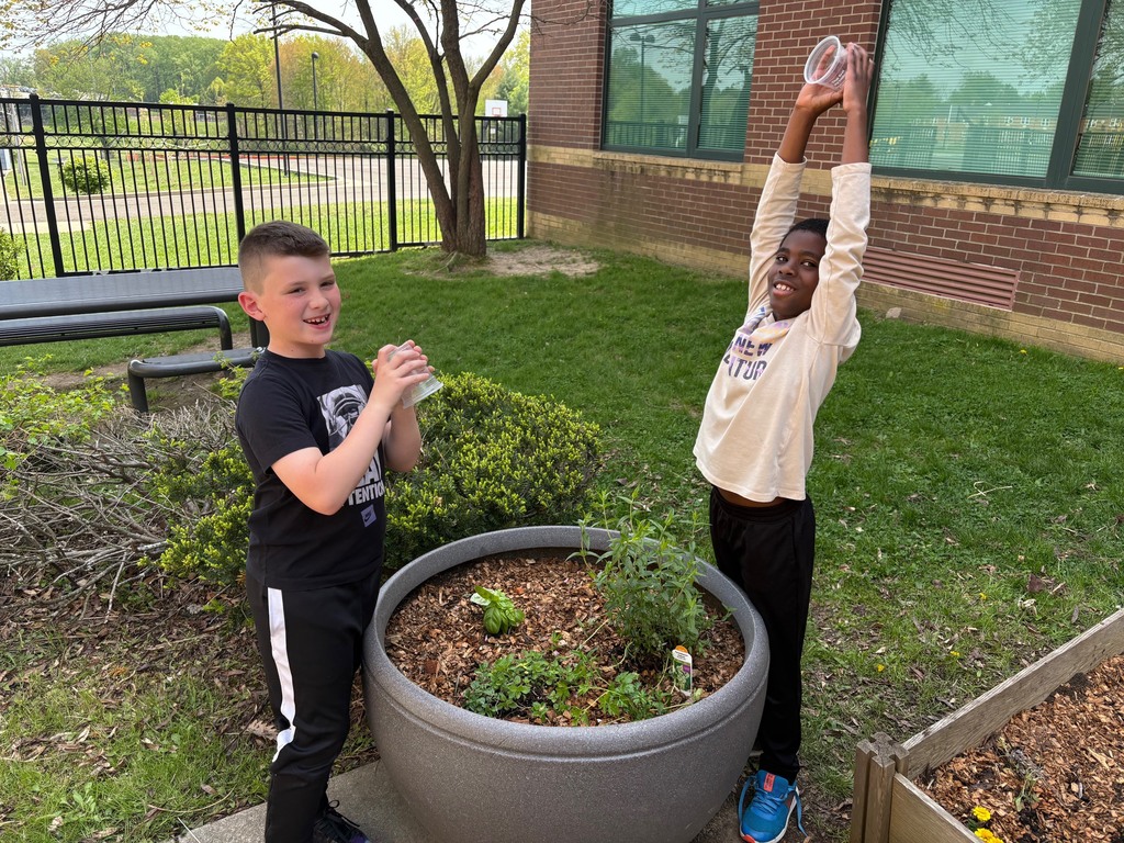 second graders watering the plants