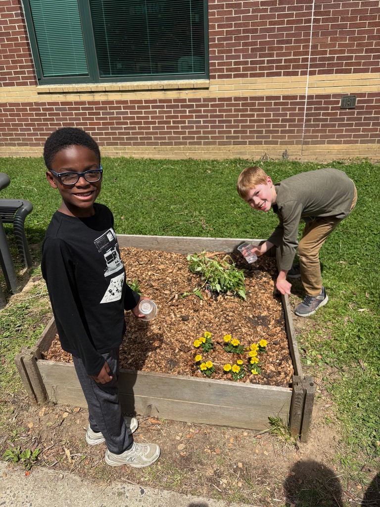 second graders watering the plants