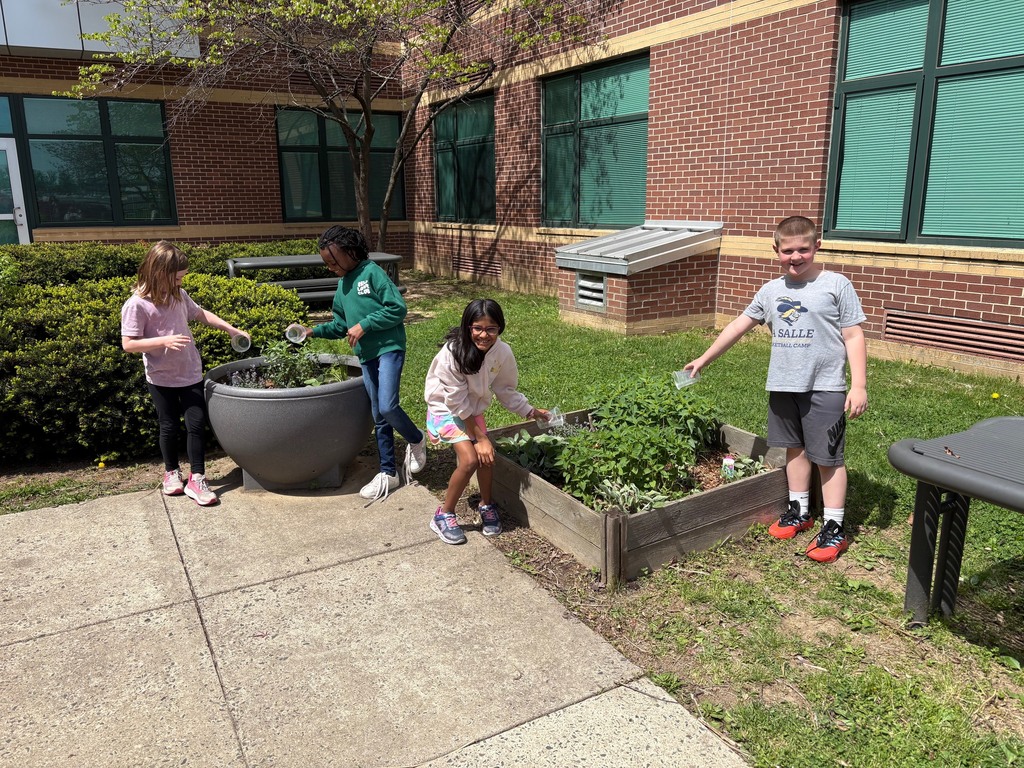 second graders watering the plants