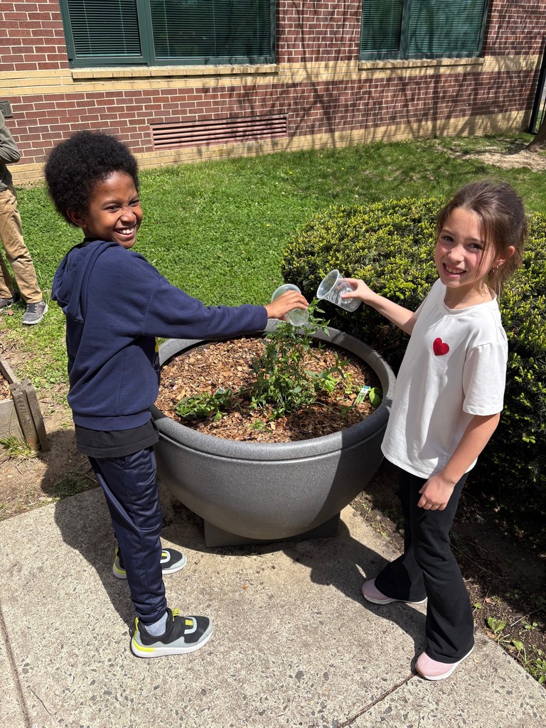 second graders watering the plants