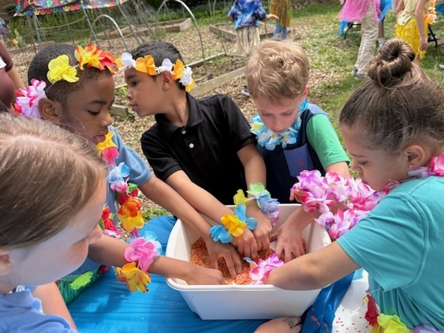 Several students dig into a tray of beads  at McKinley's Autism Awareness event