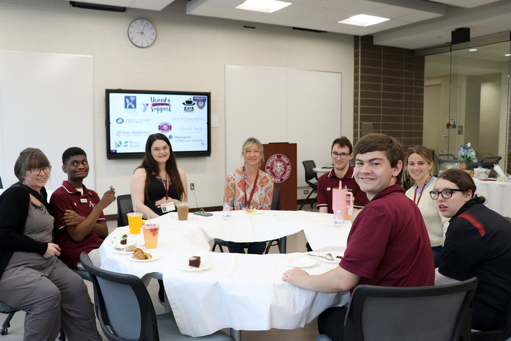 ACTIVE students sit at a table with staff at the breakfast