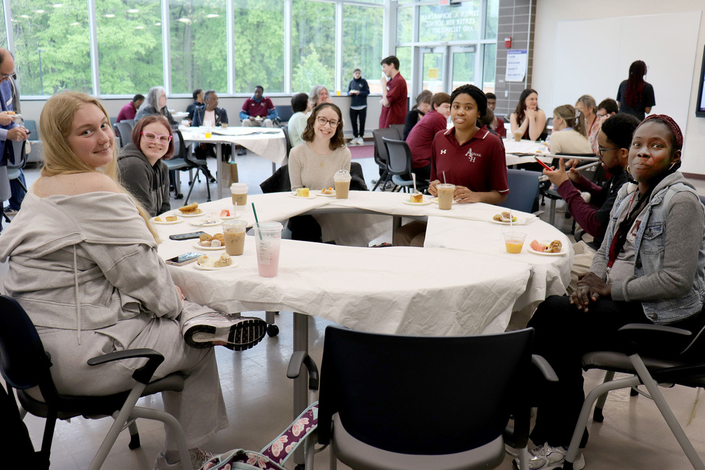 Volunteers join an ACTIVE Academy  student sitting at a table at the annual ACTIVE Academy end-of-year breakfast.
