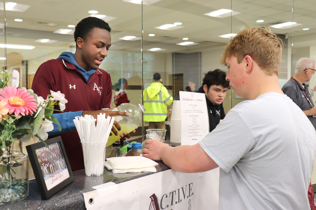 An ACTIVE student serves a beverage to a student volunteer 