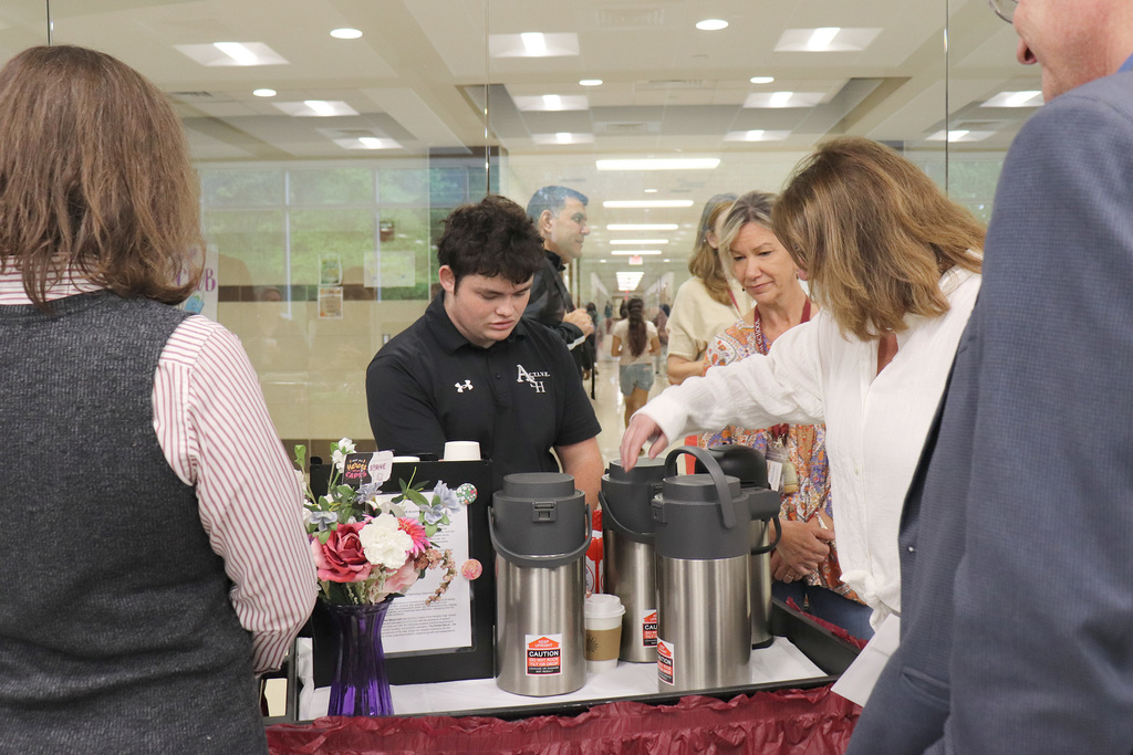 An ACTIVE Academy student serves beverages to breakfast attendees.