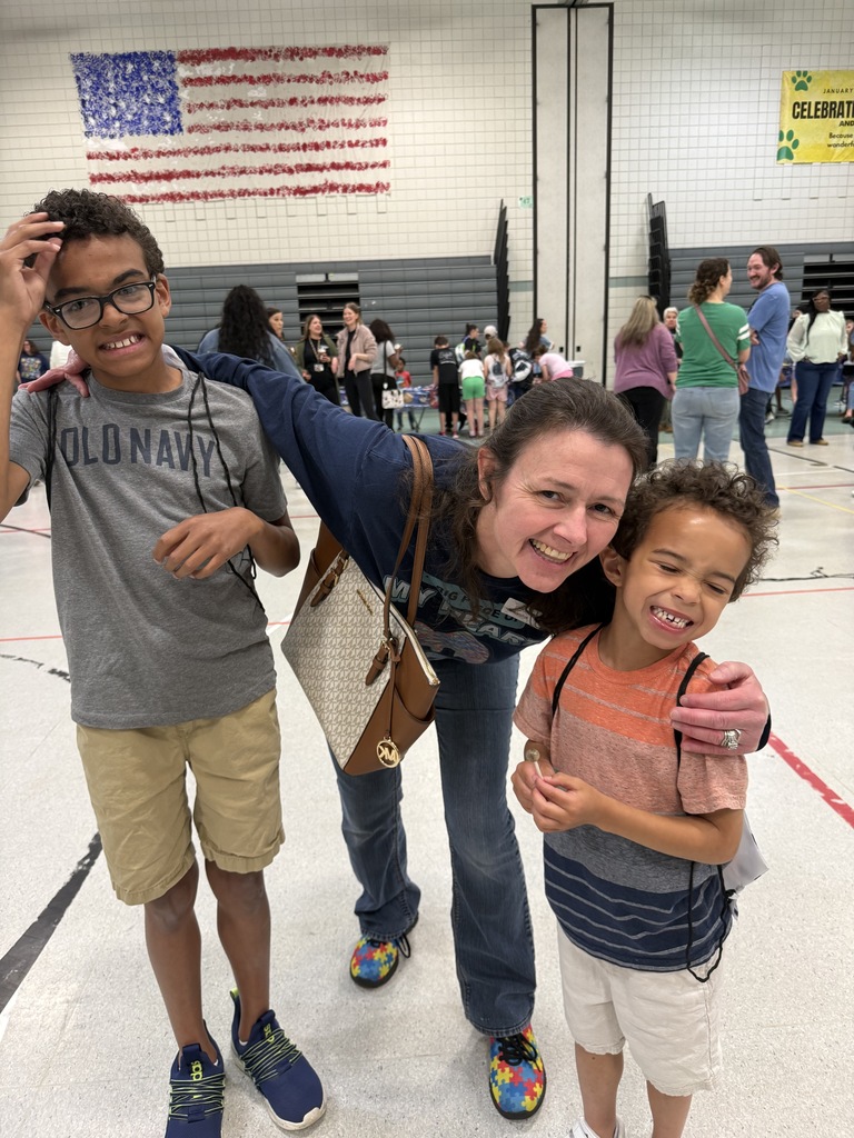 Student smiling with special guests at the Autism Event