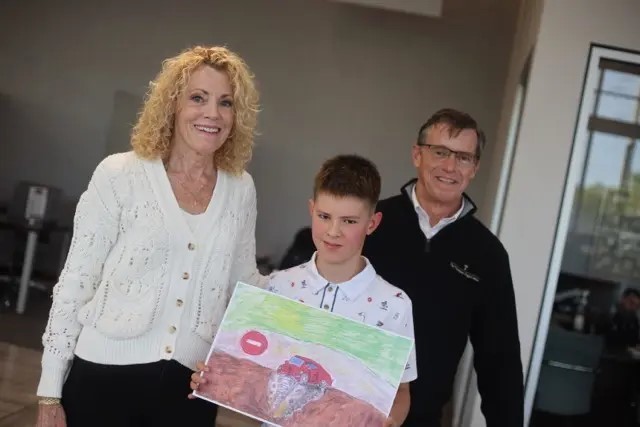 Grand prize winner, Tim and his drawing, alongside Thompson Toyota owners. 