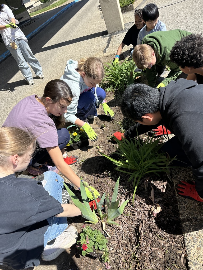 Image of students in the Going Green Club added colorful annuals to the garden by the school’s main entrance to brighten the day of those who work at and visit our school.  