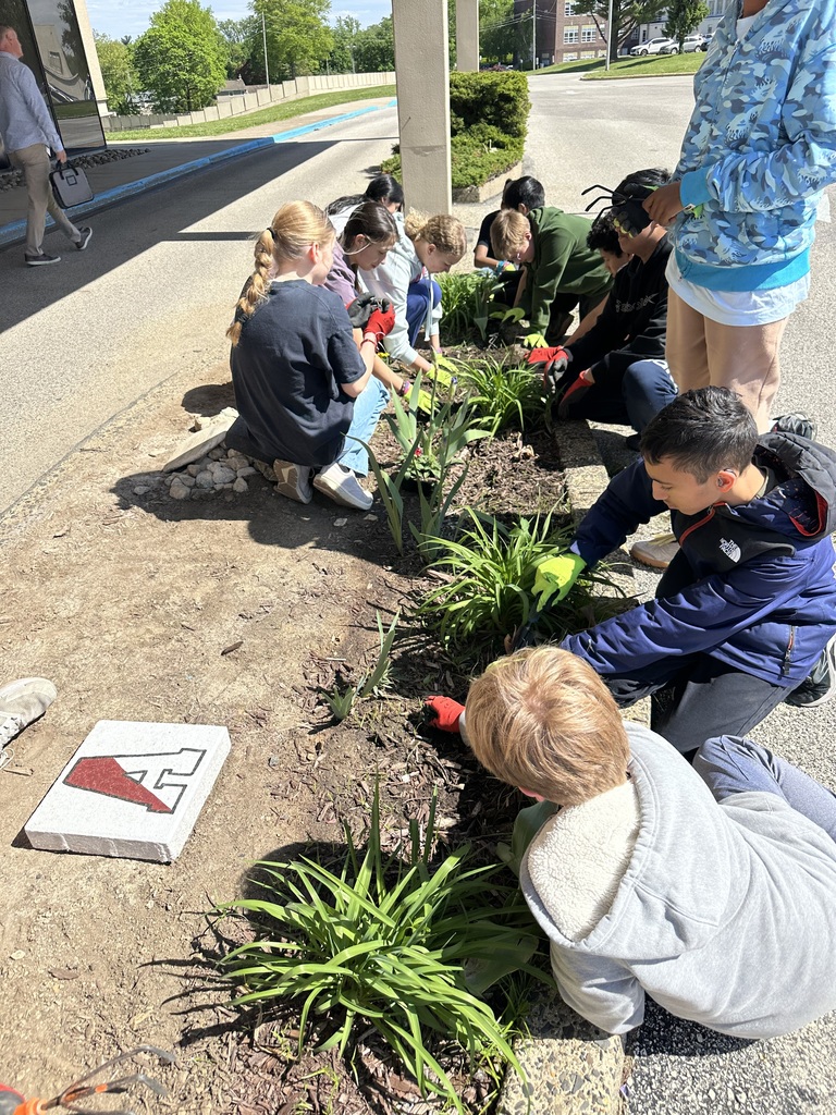 Image of students in the Going Green Club added colorful annuals to the garden by the school’s main entrance to brighten the day of those who work at and visit our school.  
