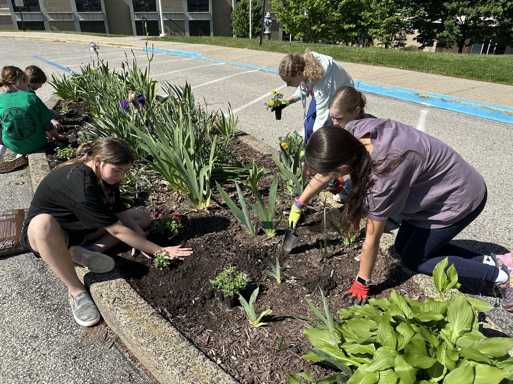Image of students in the Going Green Club added colorful annuals to the garden by the school’s main entrance to brighten the day of those who work at and visit our school.  