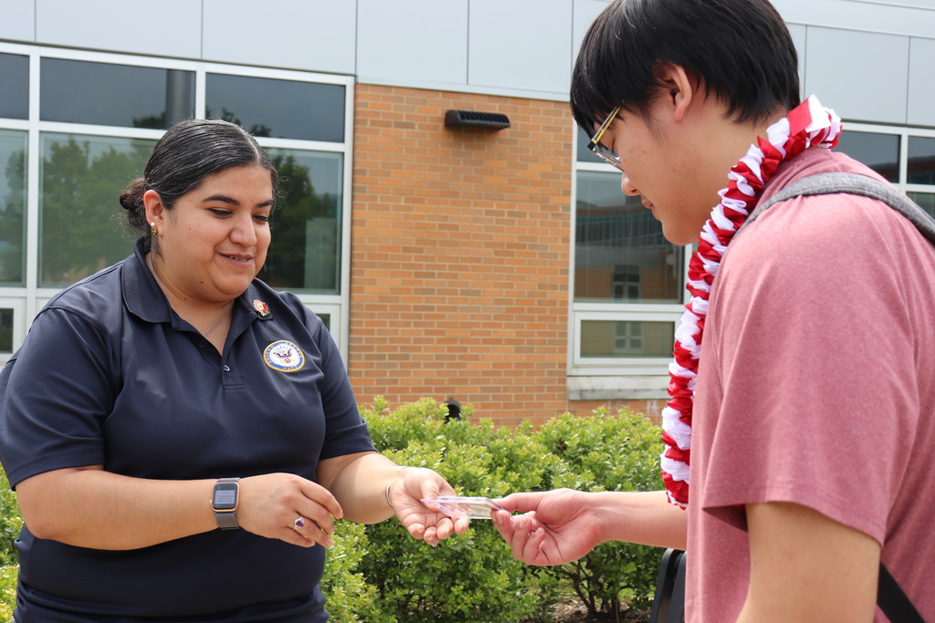 Senior Kevin is recognized by Ms. Vanassche for his service to the Military Club
