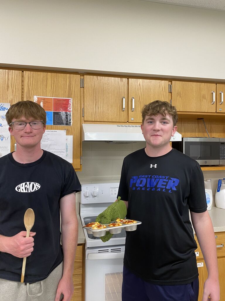 Abington High School students smiling at camera while baking 