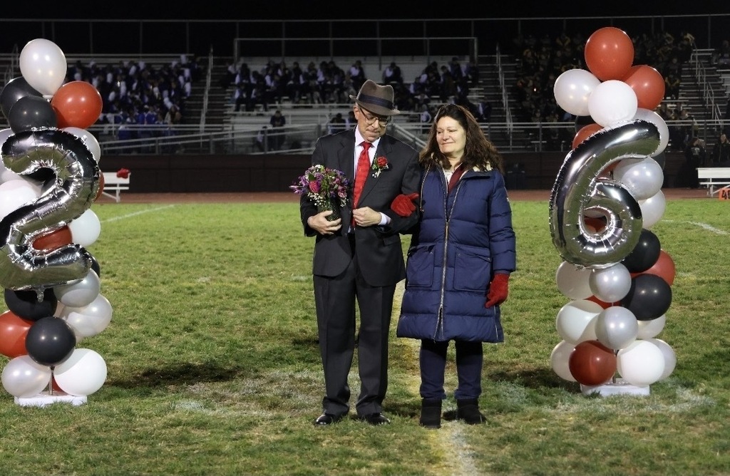 Mr. Detato walking alongside his wife at his last Bands in the Boneyard (ASHS Marching Band home show)