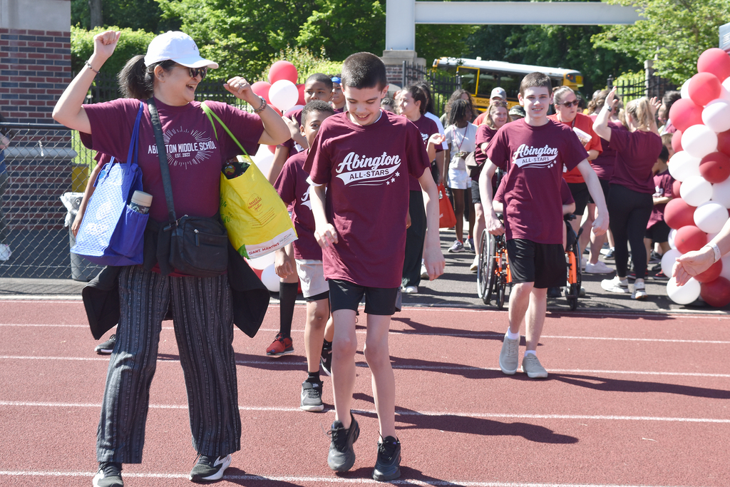 Students and staff cheer while they enter Schwarzman stadium