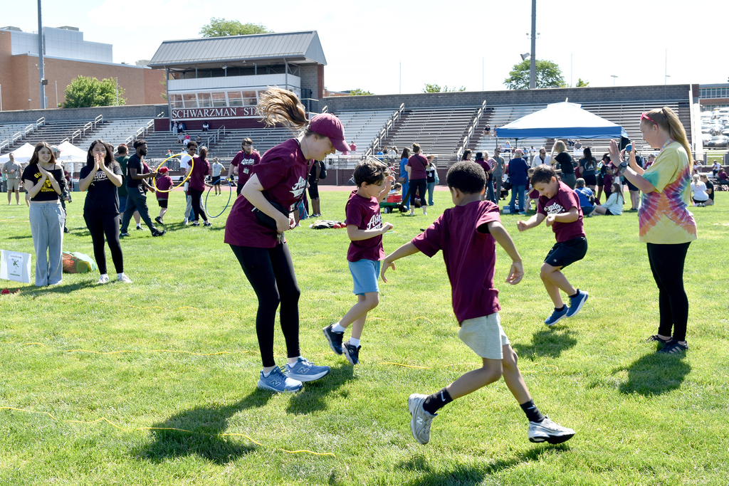 Staff members participate in a jumping event with students