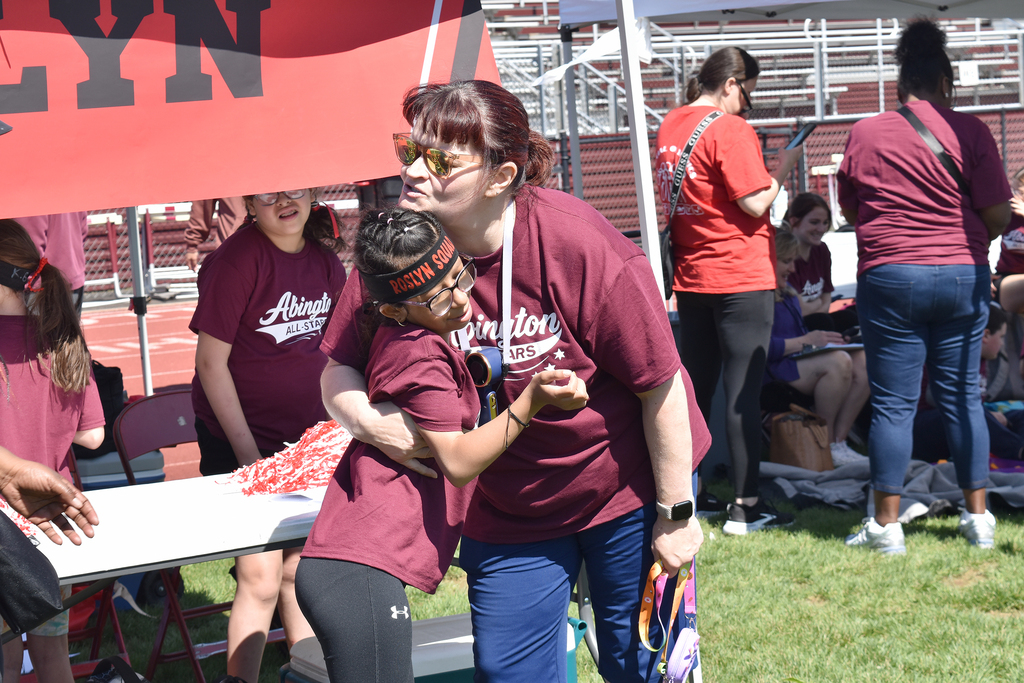 A staff member gives a student a hug