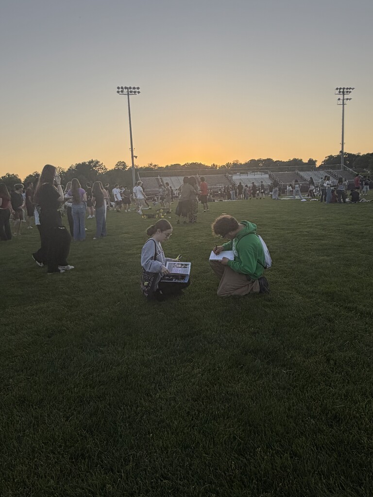 Students sign each other's yearbooks at Senior Sunset
