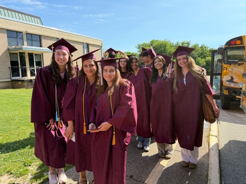 Students line up to enter Abington Middle School in caps and gowns