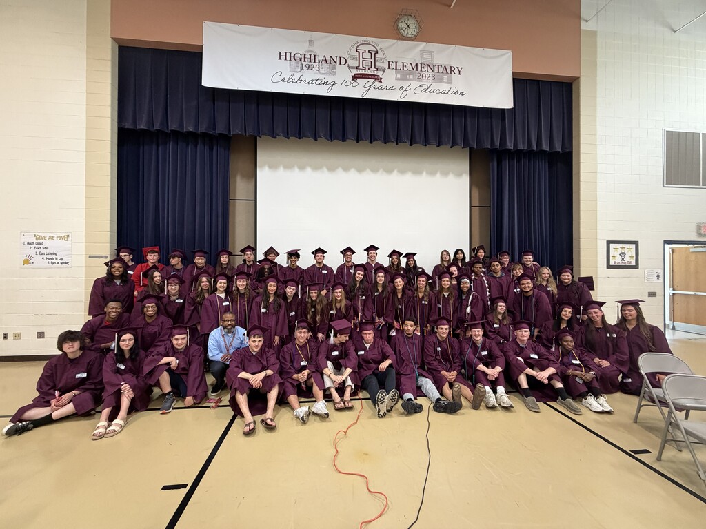 Students at Highland take a group photo in their caps and gowns