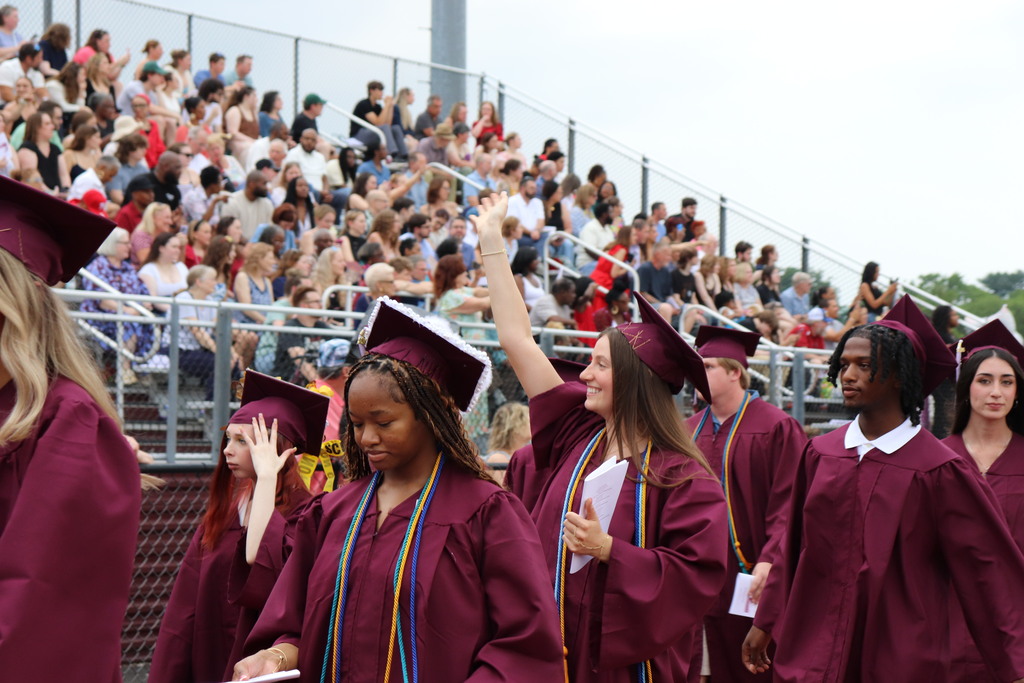 Graduate in line waves to the crowd