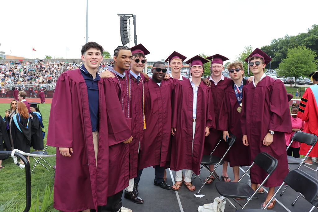 Group of graduates in caps and gowns on the stage
