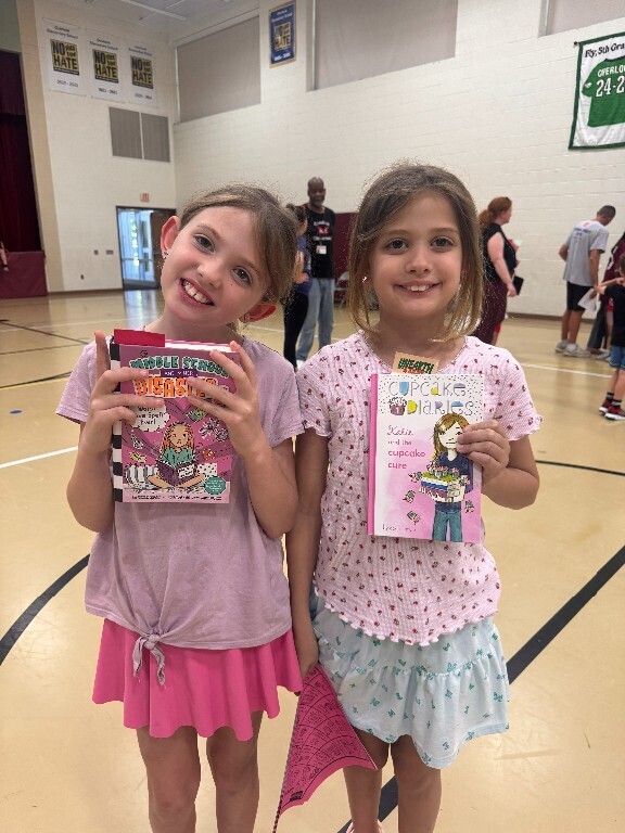 Two Overlook students hold books they were given at the summer resource fair.