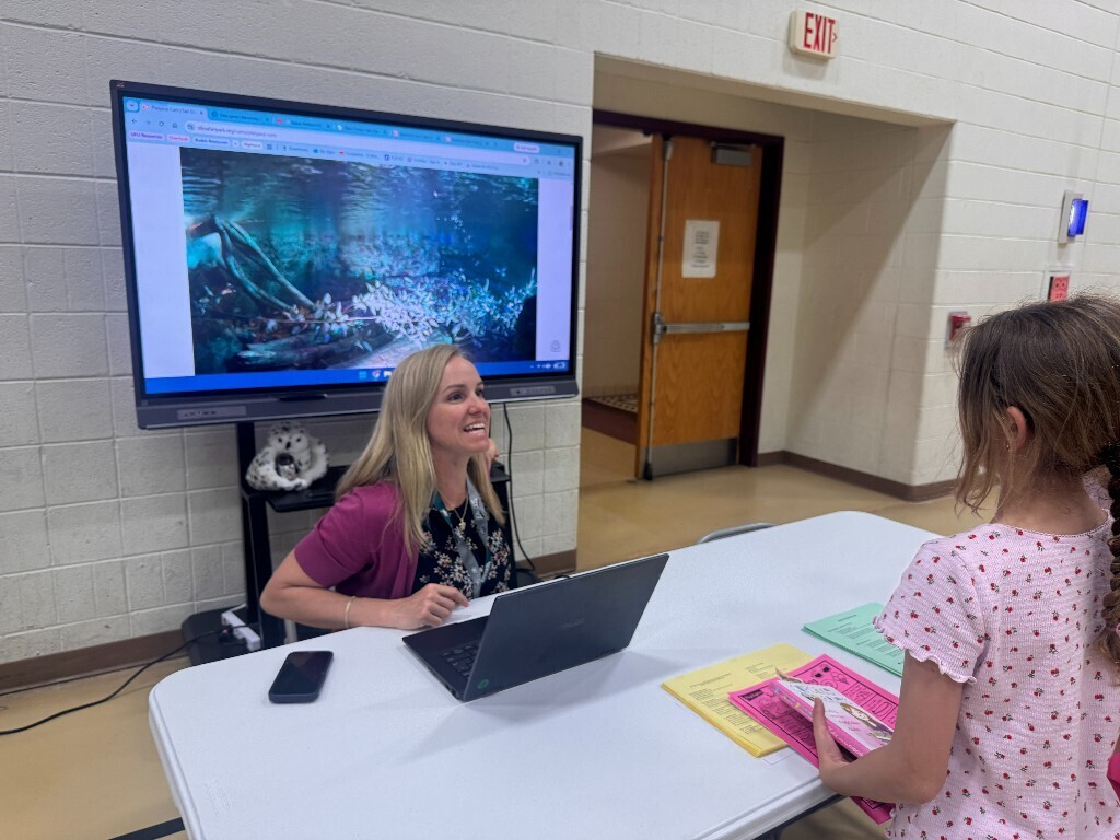 An Overlook teacher speaks to a student and her family regarding summer resources.