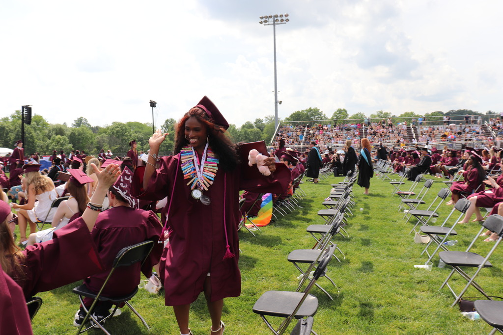 Graduates high-five each other at Commencement