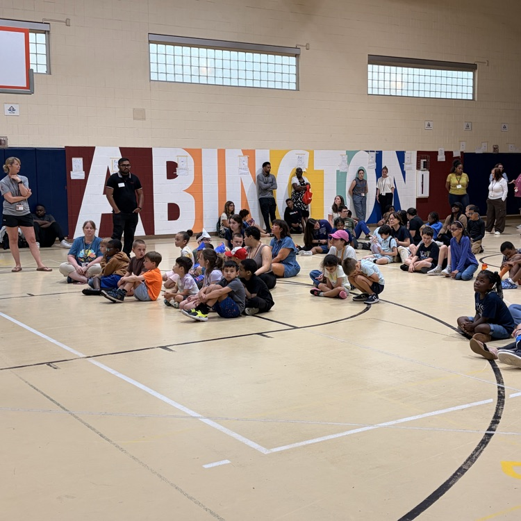 Officer Jones and Shadow talk to a gymnasium of students