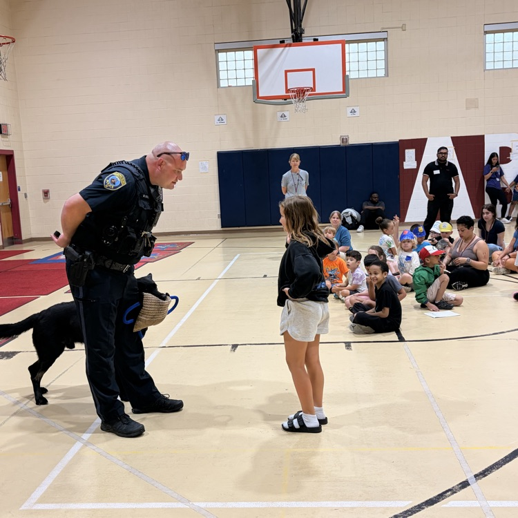 Officer Jones and Shadow talk to a gymnasium of students