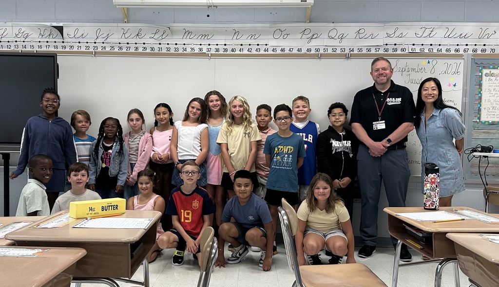 Dr. Fecher with students and their teacher in a classroom