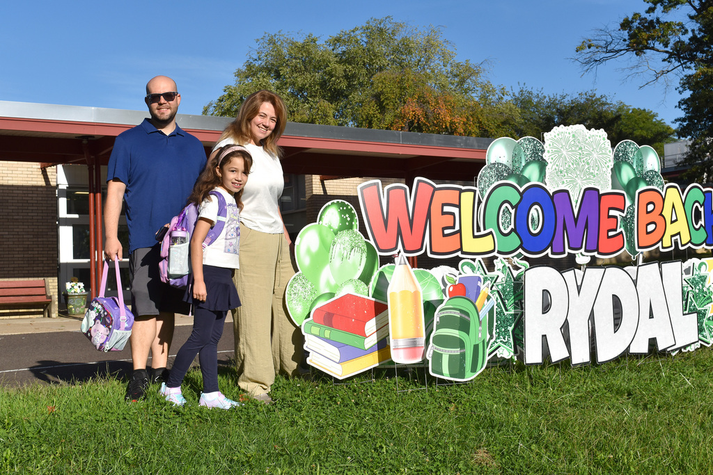 Student and their parents with a Welcome Back Rydal sign