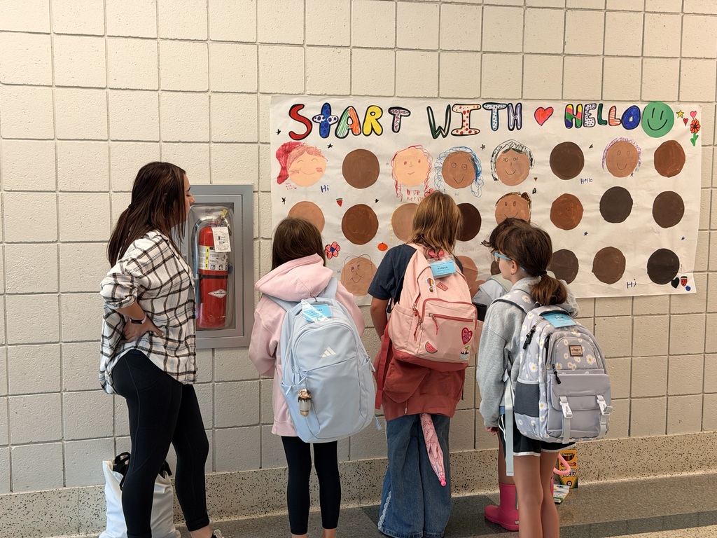 students adding to a start with hello bulletin board
