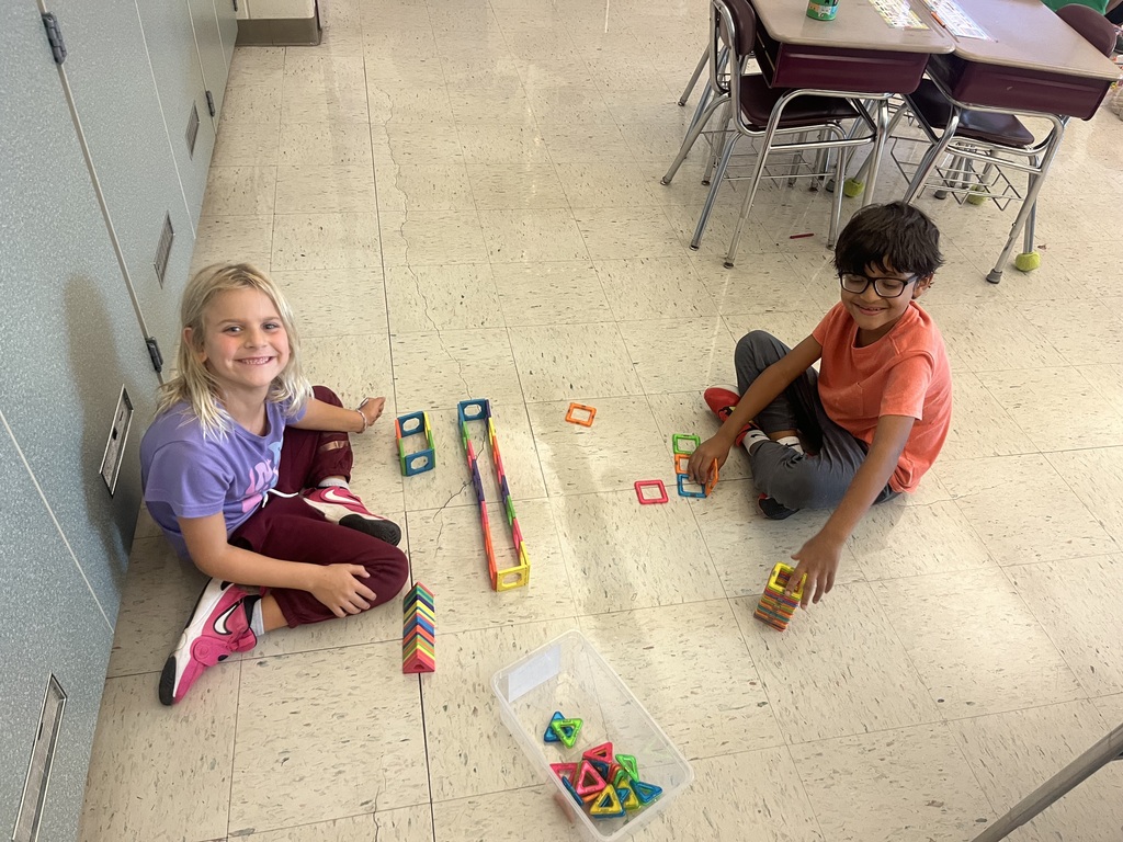 students smiling with their projects