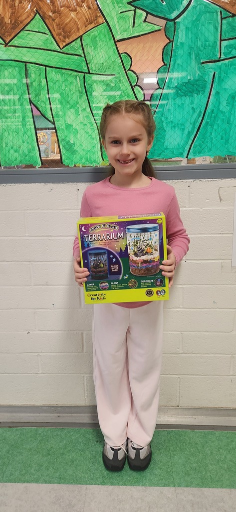 Student holding a build your own terrarium kit. 