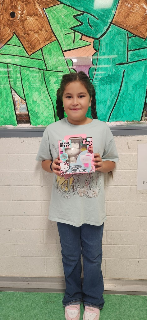 Student holding painting craft kit.