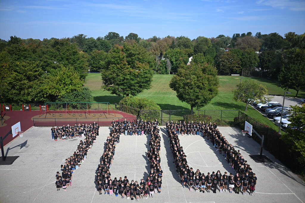 Students gathered on the playground to form a 100