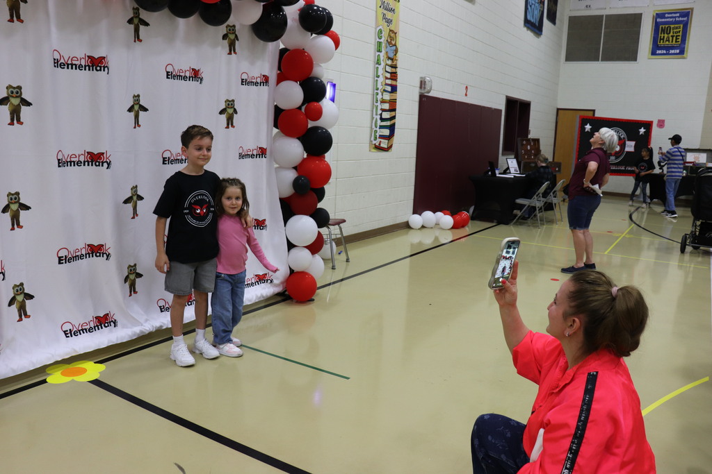 Families took photos in front of the step-and-repeat backdrop